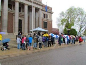 photo by Carolyn Bertsch Roughly 50 people gathered in the rain outside of the Stearns County Courthouse to participate in the National Day of Prayer gathering on May 7,  led by Pastor Carol & Pastor Geary, founders of Place of Hope Ministries.  During the course of an hour, prayers were said for the government, law enforcement officers, churches, military, families, education, media, and businesses. After prayers were said, the crowd was led into song.
