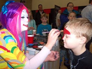 Hunter Williams, 7, of Sartell, gets his face painted at the "Just 4 Laffs" booth at Sartell Community Expo. 