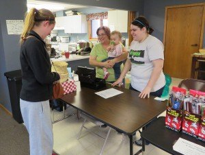 photo by Cori Hilsgen Albany resident Rachel Ramacher, 15, visits with Susan Curtis, one-year-old Amelia Curtis and Alana Curtis (left to right) at the Resurrection Lutheran Church garage sale.  