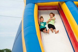 photo by Jack Hellie Abby Kuklok (left) and McKenzie Lunquist, both of Sartell, careen down an inflatable slide at the Libertyville event June 13 in Pinecone Regional Park. The event was part of Sartell SummerFest 2014. 