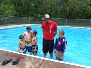 photo by Dennis Dalman YMCA lifeguard Tim Immelman of Sartell stands with pool visitors June 9 at the wading pool in Watab Park. Left to right are brothers Jacob, Anthony and Caleb Larson of Sauk Rapids and Oliver Eikmeier of Sartell. The grandmother of the Larson boys, Barbara Mills of St. Cloud, said she was babysitting her grandsons and decided they would enjoy some cool fun at the Watab pool.
