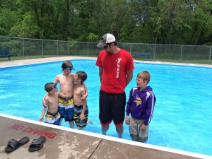 photo by Dennis Dalman YMCA lifeguard Tim Immelman of Sartell stands with pool visitors June 9 at the wading pool in Watab Park. Left to right are brothers Jacob, Anthony and Caleb Larson of Sauk Rapids and Oliver Eikmeier of Sartell. The grandmother of the Larson boys, Barbara Mills of St. Cloud, said she was babysitting her grandsons and decided they would enjoy some cool fun at the Watab pool. 