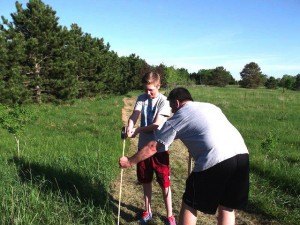 contributed photo Rod Neuenschwander and his son, Mason, pound in stakes to demarcate the perimeter of a dog park in Pinecone Central Park. By knowing the exact fence-perimeter, the group of volunteers, dubbed DogPAK, will be able to be specific when advertising for bids for fencing.  