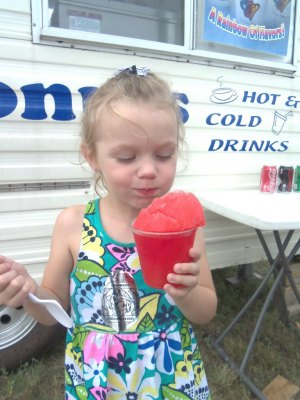 photo by Dennis Dalman Josie Barker, Sartell, savors a cold-sweet mouthful of a snow cone at the Rock ‘n’ Block party Saturday in Sartell. Early in the evening rain threatened the event, but an hour later it cleared up and all was well for the many people who enjoyed the event. 