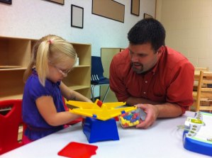 photo by Logan Gruber Three-year-old Emmaleigh Kinnear plays with Tom Schnabel, a pre-school and ECFE teacher at Colts Academy's open house Tuesday evening.