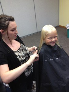contributed photo Shaina Poepping of Cedar Street Hair Salon in St. Joseph cuts the hair of Morgan Wiese at a back-to-school event at Resurrection Lutheran Church last weekend.