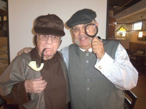 photo by Dennis Dalman Joe Pfeifle of Sartell (left) as Sherlock Holmes and Jeff Falkingham as Dr. Watson spoof a bit during their presentation at Drakes Fine Food and Spirits restaurant and bar in Sartell. The place is now open to the public, as well as residents of Country Manor in which it is located. 