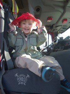 photo by Dennis Dalman Corbin Olson of Litchfield grins with joy as he tries on his fire hat at the Sartell-LeSauk Fire Department Open House Oct. 9. Olson was visiting his grandparents, Bob and Lou Hanson of Sartell, who brought him to see the fire trucks.