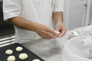 photo by Logan Gruber Tahir Sandhu presses cranberries into cup-naan Monday evening to make samples for customers.