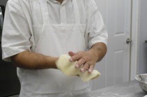 photo by Logan Gruber A customer ordered some No-nonsense Naan Monday night, and Tahir Sandhu can be seen here forming it before stamping it and placing it in the oven.