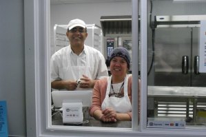 photo by Logan Gruber Tahir Sandhu and Gwen Williams pose in the window of their new bakery in the northeast corner of Minnesota Street Market.