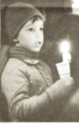 photo by Stuart Goldschen A candle illuminates the hope in the eyes of one small boy at the candlelight song gathering.