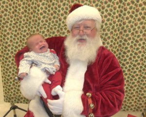 Photo by Dennis Dalman Micciah Rodriguez, 2-1/2, of Sauk Rapids, isn’t thrilled to be cuddled by Santa, although seconds later, after she spilled a few tears, she was all smiles. This photo was taken at Coborn’s Super Store in Sartell during a Visit with Santa session.  