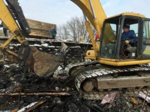 contributed photo A neighbor was kind enough to bring his backhoe over to assist the Theisens in removing the debris from the site of the fire.  Todd Theisen said the debris was two feet thick, and was frozen to the ground.