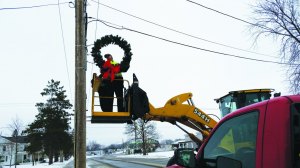 photo by Logan Gruber Jim Marthaler, along with other members of the St. Joseph Public Works department, placed wreaths around town on Dec. 11.  "Christmas isn't cancelled!" Marthaler said, after fiddling with the lights for a short while.