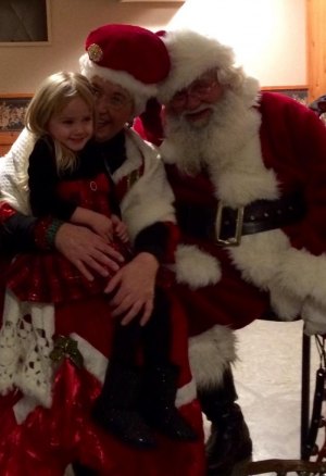 contributed photo Kenna Rathbun, 3 years old, of St. Joseph, enjoyed snuggling with Mrs. Clause and her mister during the festivities at El Paso.