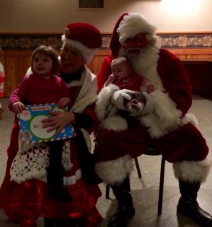 contributed photo 3-year-old Kayley Prom and 6-month-old Nikki Prom, daughers of John and Alecia of St. Joseph, enjoyed meeting Santa and Mrs. Clause at the Little Saints Academy Holiday Social at El Paso.
