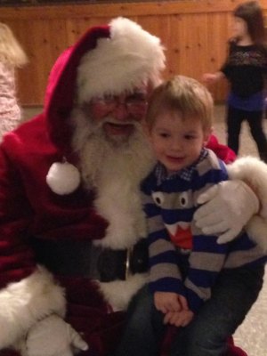 contributed photo Liam Emery, Sartell, snuggled with the man in the red coat himself during Little Saints Academy's Holiday Social on Dec. 16 at El Paso in St. Joseph.