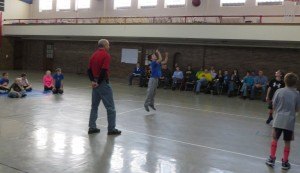 photo by Cori Hilsgen Abraham Berg-Arnold, 9, (center) shoots a free-throw as parents and other participants watch during the Knights of Columbus Free-throw competition held Jan. 25 in All Saints Academy in St. Joseph.