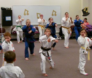 photo by Carolyn Bertsch The Sartell Community Showcase on Feb. 28 featured a demonstration by students of National Karate Academy of Martial Arts under the direction of Ms. Christa Jordahl. From left to right, front row: Cohen Guggisberg, Autumn Blommer, Jade Au. Middle row: RJ Carstensen-Boe, Allyson Carstensen-Boe, Emily Sather. Back row: Marysta Laidlaw, Kaylean Laidlaw, Kristi Laidlaw. Brandon Au (backed turned) looks on.