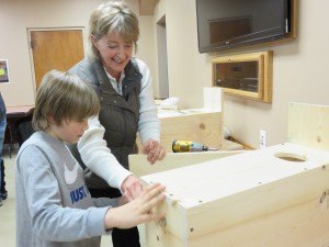 photo by Logan Gruber Ben Sjaaheim and his mother, Cheryl Wilhelmi, open the side of their wood-duck house after completing it Monday night during the St. Joseph Rod & Gun Club's birdhouse building night.