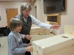 photo by Logan Gruber Ben Sjaaheim and his mother, Cheryl Wilhelmi, open the side of their wood-duck house after completing it Monday night during the St. Joseph Rod & Gun Club's birdhouse building night.