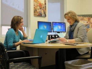 photo by Logan Gruber Laurie Putnam, left, and current Kennedy Principal Judy Nagel discuss the 2015-16 student schedule at Nagel's office on March 30.