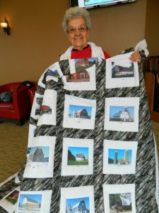 contributed photo Delrose Fischer holds a barn quilt which includes photos from 47 area barns. 