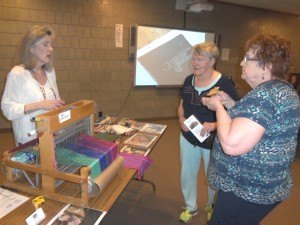 photo by Dennis Dalman Jeri Olson-McCoy, a local weaver, talks about her craft to visitors to the Hands Across the World art exhibit at the Stearns History Museum. In the middle is Jane Sarazine of Waite Park and at right is Jeannine Noska of Sartell.