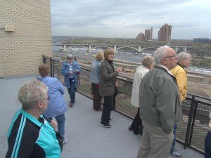 photo by Dennis Dalman Members of the Sartell Senior Connection take a glimpse of the Mighty Mississippi April 24 during a tour of several places in Minneapolis. In this photo, the group is standing on an observation deck of the Flour Mill Museum, overlooking St. Anthony Falls, which was the birthplace of the big city when the lumber and flour industries boomed in the 19th Century. The group of 36 senior citizens took the Northstar Commuter Rail for the day trip. After the museum visit, they dined at the Old Spaghetti Factory, then took a tour of the nearby Guthrie Theater. 