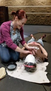 contributed photo Julia Olson, scenic painter for Sartell High School’s production of Into the Woods, applies plaster to Maia Trombley’s face to create a mask. Trombley plays the witch in the musical. 