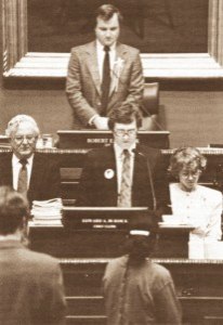 photo courtesy of Bernie Omann Jerry Wetterling prays for his son, Jacob, before members of the Minnesota House of Representatives with his wife, Patty, at his side. The Wetterlings were invited to address the House and the state Senate on Jacob's abduction and the issue of missing children in general on April 4. They also met with Gov. Rudy Perpich and central Minnesota legislators. Perpich indicated he would establish a commission on child abduction to make recommendations to the 1991 legislature for changes in child safety laws. The appearance of the Wetterlings was arrange by Rep. Jeff Bertram, DFL-Paynesville. Pictured above Jerry Wetterling is House Speaker Robert Vanasek; to his right is Chief Clerk Edward Burdick.