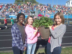 photo by Dennis Dalman Three girls hold up the flowers presented to their departing principal. From left to right are Sarah Owens, Kelley Vande Vrede and Hannah Congdon.