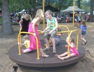 photo by Dennis Dalman Kids have fun spinning around on a merry-go-round during River Days Food Fest in Municipal Park, Sauk Rapids, June 27.