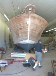 photo by Dennis Dalman This behemoth of a boat, a 50-feet long cabin cruiser, is one of the projects Little Rock Boat Works is committed to doing. The entire boat will be restored to virtually pristine condition. In the foreground is David Watts, owner of the company. 