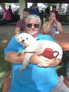 photo by Dennis Dalman Jeff Tinklenberg of St. Cloud holds his buddy, Pattie, at River Days Food Fest June 27 in Sauk Rapids.