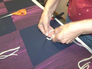 photo by Dennis Dalman The hands of Nancy Anderson and the other quilters are nimble and adept at tying notes lickety-split.