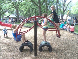 photo by Dennis Dalman Three girls enjoy rocking on a playground toy at River Fest Food Days.