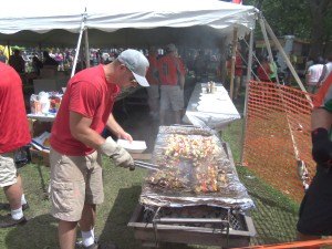 photo by Dennis Dalman Nate Rueter serves up Manea's Meats' shish-ka-bobs at River Days Food Fest. Rueter is a member of the Manea's Meats baseball team that plays Monday nights in Sauk Rapids' Bob Cross Park.