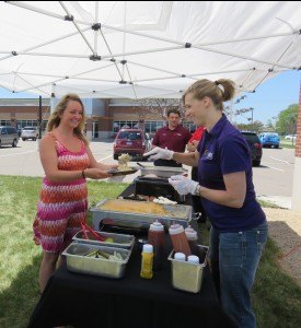 photo by Logan Gruber Robyn Brinkman (right) serves up cheesy mashed potatoes to a Cold Spring woman on June 12 during Central Minnesota Credit Union's annual Member Appreciation Day. 