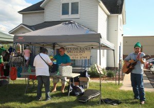 photo by Carolyn Bertsch Music was in the air at the Sauk Rapids Community Crawl on Thursday, June 18. Ryan Golombecki of Sartell, who is also a Hoff’s Insurance agent, plays his guitar while owner, Jerry Hoff, helps a customer. 