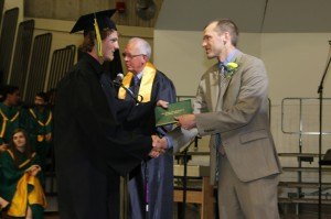 photo by Andrea Skillingstad (UNKOWN STUDENT) receives his diploma from Phil Rogholt, school board member, during the Sauk Rapids-Rice High School graduation ceremony May 26 a Halenbeck Hall at St. Cloud State University.