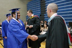 Nathan Frank is congratulated on his graduation by teacher Greg Henning.